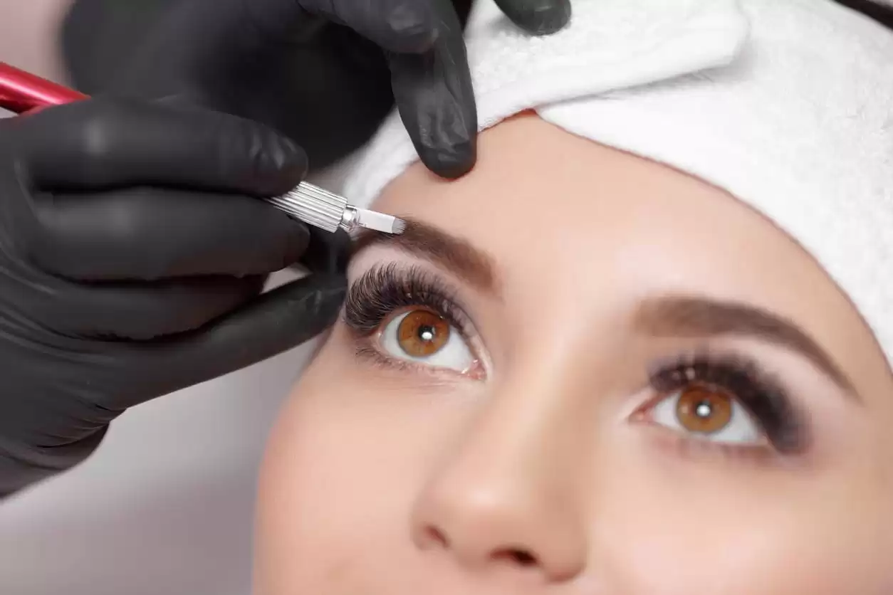 A woman getting her eyebrows done in a beauty salon.